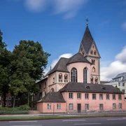 St. Mary in Lyskirchen Die romanische Kirche Sankt Maria Lyskirchen in Köln, umgeben von Bäumen und moderner Bebauung.The Romanesque church of St. Maria Lyskirchen in Cologne, surrounded by trees and modern buildings.