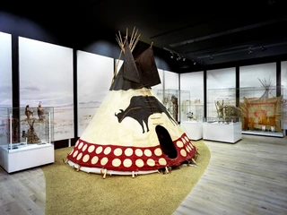 Rautenstrauch-Joest-Museum Museumsausstellung mit traditionellen Tipis, umgeben von Vitrinen mit Artefakten. Elegante Präsentation.Museum exhibition with traditional tipis surrounded by display cases with artifacts. Elegant presentation.