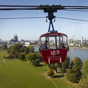 Cologne cable car Die Kölner Seilbahn schwebt majestätisch über den Rhein, mit dem Kölner Dom und der Skyline der Stadt im Hintergrund.The Cologne cable car floats majestically over the Rhine, with Cologne Cathedral and the city skyline in the background.