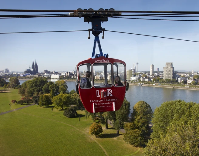 Cologne cable car Die Kölner Seilbahn schwebt majestätisch über den Rhein, mit dem Kölner Dom und der Skyline der Stadt im Hintergrund.The Cologne cable car floats majestically over the Rhine, with Cologne Cathedral and the city skyline in the background.