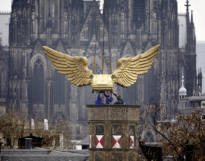 Golden flying car Goldenes Auto mit imposanten Flügeln schwebt über Köln vor dem majestätischen Kölner Dom.Golden car with imposing wings hovers over Cologne in front of the majestic Cologne Cathedral.