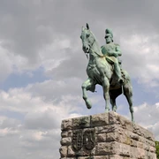 Equestrian statue of Emperor Frederick III. Reiterstandbild von Kaiser Friedrich III. in Köln: Ein bronzenes Reiterdenkmal auf einem steinernen Sockel unter dramatischem Himmel.Equestrian statue of Emperor Frederick III in Cologne: a bronze equestrian monument on a stone pedestal under a dramatic sky.