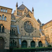 Synagogue Romanische Fassade der Synagoge aus Sandstein mit großen, runden Fenstern und spitzen Türmen.Romanesque façade of the synagogue made of sandstone with large, round windows and pointed towers.
