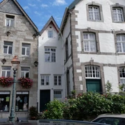 Kornelimünster Drei historische Fachwerkhäuser mit blumengeschmückten Fassaden stehen aneinandergereiht. Das Mittlere mit der Hausnummer 17 ist sehr schmal.