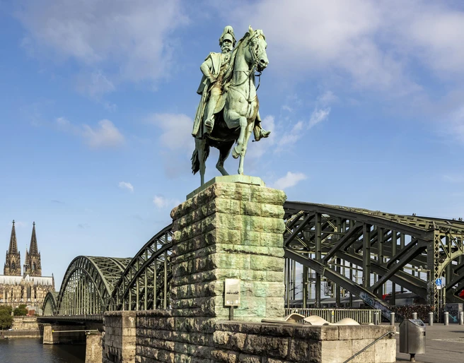 Equestrian statue of Kaiser Wilhelm I. Ein majestätisches Reiterstandbild von Kaiser Wilhelm I., im Hintergrund der Kölner Dom und die Hohenzollernbrücke.A majestic equestrian statue of Kaiser Wilhelm I, with Cologne Cathedral and the Hohenzollern Bridge in the background.