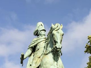 Equestrian statue of King Frederick William IV. Das Reiterstandbild von König Friedrich Wilhelm IV. in Köln zeigt die bronzene Figur des Monarchen auf einem majestätischen Pferd, umrahmt von grünen Bäumen und einem strahlend blauen Himmel.The equestrian statue of King Frederick William IV in Cologne shows the bronze figure of the monarch on a majestic horse, framed by green trees and a bright blue sky.