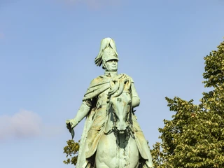 Equestrian statue of King Frederick William IV. Das bronzene Reiterstandbild zeigt König Friedrich Wilhelm IV. von Preußen hoch zu Ross. Es thront imposant auf einem soliden Steinsockel. Dichtes Laub umrahmt die Statue, die bei klarem Himmel eindrucksvoll strahlt.The bronze equestrian statue shows King Frederick William IV of Prussia on horseback. It is enthroned imposingly on a solid stone plinth. Dense foliage frames the statue, which shines impressively when the sky is clear.