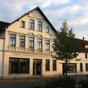 Schinkenmuseum-Apen Das Bild zeigt ein traditionelles Gebäude mit einem Schild, das "Traditions-Schinkenräucherei & Schinkenmuseum" anzeigt.