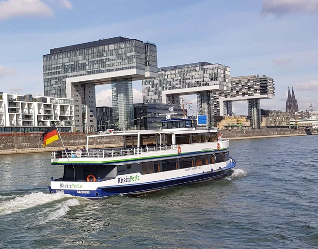 Kölntourist passenger boat service Ein Ausflugsschiff namens 'RheinPerle' fährt vor der modernen Architektur der Kranhäuser in Köln.An excursion boat called 'RheinPerle' sails in front of the modern architecture of the crane buildings in Cologne.