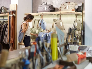 Belgian Quarter Das Bild zeigt eine Person, die in einem Lederwarengeschäft in Köln einkauft und Taschen betrachtet.The image shows a person shopping in a leather goods store in Cologne and looking at bags.