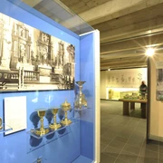 Museum im Kloster Saarn Ausstellungsstück im Museum im Kloster Saarn mit historischen Kelchen und schwarz-weißen Fotografien.