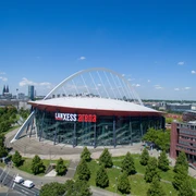 Lanxess Arena Die Lanxess Arena, moderne Architektur in Köln, umgeben von grüner Landschaft und urbanem Flair.The Lanxess Arena, modern architecture in Cologne, surrounded by green countryside and urban flair.