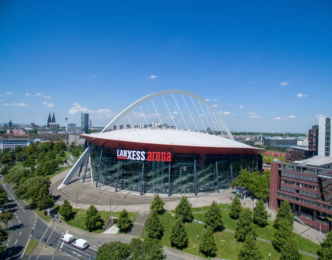 Lanxess Arena Die Lanxess Arena, moderne Architektur in Köln, umgeben von grüner Landschaft und urbanem Flair.The Lanxess Arena, modern architecture in Cologne, surrounded by green countryside and urban flair.