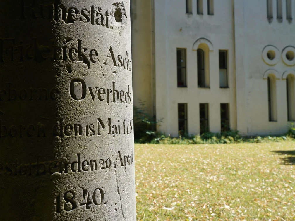 hx-petrikirche-thomashampel alter Grabstein mit unleserlicher Inschrift auf Friedhofswall