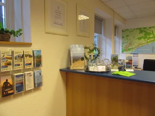 Counter im Haus des Gastes Ein Empfangstresen mit Prospekten und touristischen Informationen im Haus des Gastes, umrahmt von hellem Interieur.