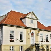 Altes Rathaus Ein altes Gebäude mit rotem Ziegeldach und weißen, symmetrischen Fassadenfenstern steht majestätisch.