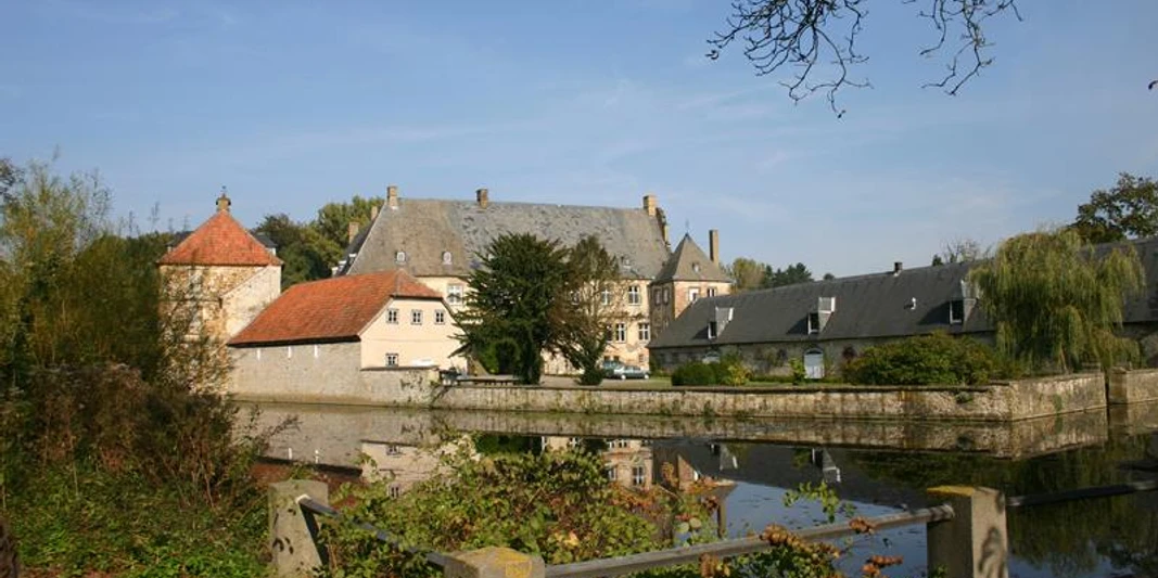 Halle Westfalen, Wasserschloss Tatenhausen Historische Wasserschlossanlage mit Hauptgebäude, Nebengebäuden, umgeben von einem Wassergraben.