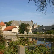 Halle Westfalen, Wasserschloss Tatenhausen Historische Wasserschlossanlage mit Hauptgebäude, Nebengebäuden, umgeben von einem Wassergraben.