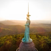 Hermannsdenkmal bei Sonnenuntergang Das imposante Hermannsdenkmal ragt bei Sonnenuntergang über die bewaldete Landschaft des Teutoburger Waldes.