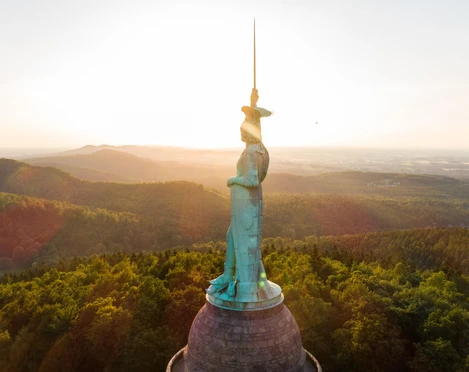 Hermannsdenkmal bei Sonnenuntergang Das imposante Hermannsdenkmal ragt bei Sonnenuntergang über die bewaldete Landschaft des Teutoburger Waldes.