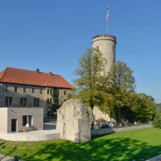 Sparrenburg Bielefeld Sicht auf die mittelalterliche Sparrenburg in Bielefeld, umgeben von Bäumen bei klarem Himmel.