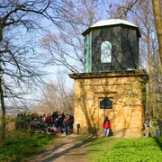 Kaffeemühle in Halle Westfalen am Hermannsweg Eine Gruppe von Menschen steht vor einem steinernen Aussichtsturm im sonnigen Wald.