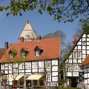 Halle Westfalen, Kirchplatz "Haller Herz" Fachwerkhäuser in einer malerischen Altstadt mit blauem Himmel und grünen Bäumen im Frühling.