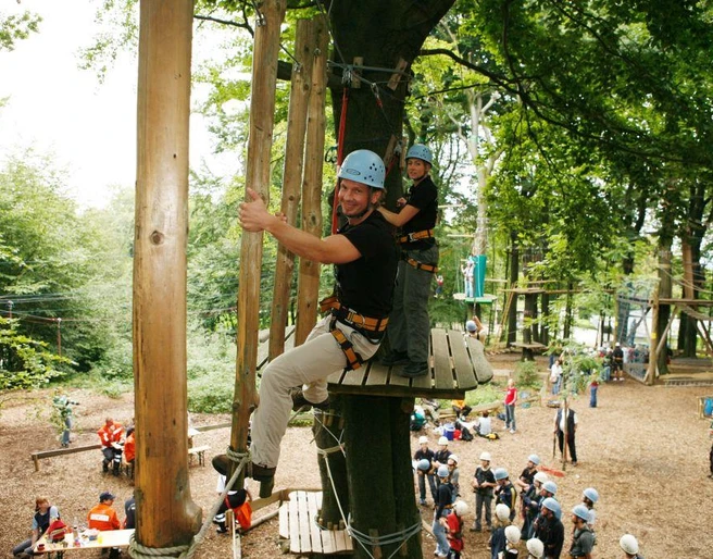 Kletterpark am Hermannsdenkmal Menschen in einem Kletterpark genießen Seilbahnen zwischen hohen Bäumen bei sonnigem Wetter.