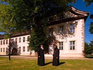 Koptisch-orthodoxes Kloster Höxter-Brenkhausen Koptisch-orthodoxes Kloster in Höxter-Brenkhausen mit zwei Mönchen im sonnendurchfluteten Garten.