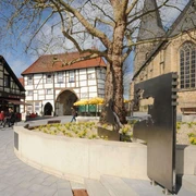 Ev. Stadtkirche Lengerich mit Römer / Friedensreiter Lengericher Stadtkirche mit modernem Römerdenkmal und historischem Fachwerkgebäude im Hintergrund.