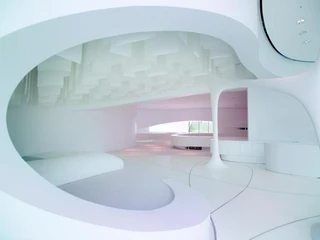 Futuristisch gestalteter, weißer Raum mit organischen Linien und großzügigem Lichteinfall.