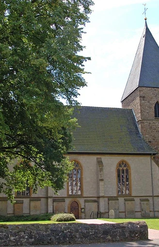 Stiftskirche in Stift Quernheim Stiftskirche in Stift Quernheim mit steinernem Glockenturm und umgebenden Laubbäumen im Sommer.