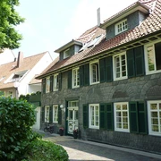 Traditionelles Wohnhaus in Fachwerkstil mit Schieferfassade und grünen Fensterläden.