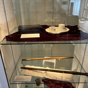 Kunstvoll arrangierte Ausstellungsstücke in einer Vitrine, darunter Teetassen und historische Accessoires.