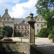 Wasserschloss Surenburg Historisches Wasserschloss Surenburg umgeben von Gärten, mit steinernem Tor und verzierter Fassade.