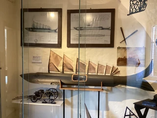 Historisches Fischmodell "Steinhuder Hecht" in einem Schaukasten, umgeben von nautischen Exponaten.