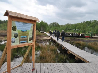 Hinweistafel am Ausstieg am Bohlenweg bei der Fahrt mit der Moorbahn in das Große Moor Westerbeck Gäste der Moorbahnfahrt am Ausstieg am Bohlenweg