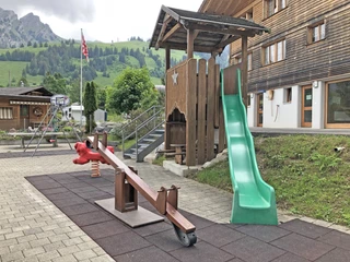 Spielplatz mit Wippe und Rutschbahn Kinderspielplatz mit grüner Rutschbahn und WippeChildren's playground with green slide and seesawAire de jeux pour enfants avec toboggan vert et bascule