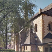 Pfarrkirche St. Laurentius, Clarholz am Kloster Historische Kirche mit romanischen Elementen neben belaubten Bäumen und angrenzenden Gebäuden.