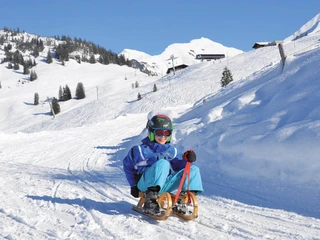 wiriehorn-schlitteln-kinder-himmel-blau-winteraktivitaet