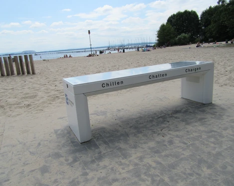 Ladebank Badestrand Weiße Düne Ladebank am Badestrand Weiße Düne mit Blick auf das Meer, leicht bewölkter Himmel im Hintergrund.