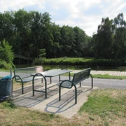 Picknickplatz an der Brücke Hagenburger Kanal Ein Picknicktisch steht an einem gepflegten Uferweg, umgeben von Bäumen und dem Hagenburger Kanal.