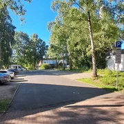 Ein ruhiger Parkplatz umgeben von hohen Bäumen an einer klaren, sonnigen Himmelstag.