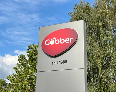 Göbber Göbber-Firmenschild unter blauem Himmel mit Bäumen im Hintergrund und Gründungsjahr seit 1888.