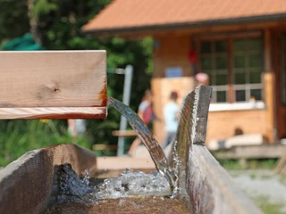 L'eau courante dans le système de caniveaux Wasser läuft von einem Holzkännel in den anderenWater runs from one wooden jug into the otherL'eau coule d'une louche en bois à l'autre
