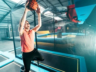Basketball im Abenteuerland Bispingen Mann springt mit Ball auf Trampolin im Abenteuerland Bispingen, ideal für Familien.