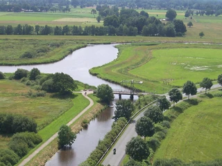 Luftaufnahme Alte Staaßenbrücke Luftaufnahme einer historischen Brücke über dem Nordloh-Kanal, umgeben von grüner Landschaft und Bäumen, mit Fahrradweg.