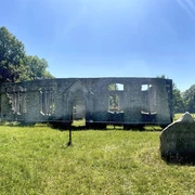 Ruinen der Haustenbecker Kirche in Schlangen mit steinernen Mauern und gewölbtem Eingangsportal im Grünen.