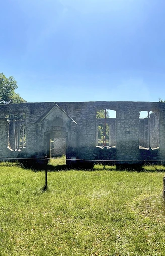 Ruinen der Haustenbecker Kirche in Schlangen mit steinernen Mauern und gewölbtem Eingangsportal im Grünen.