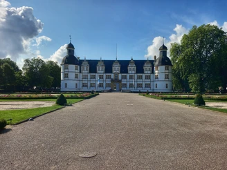 Schloss Neuhaus in Paderborn, umgeben von gepflegten Gärten, sticht mit seiner Renaissance-Architektur hervor.